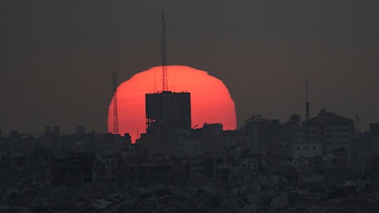 The sun sets over damaged buildings in the Gaza Strip last month.
