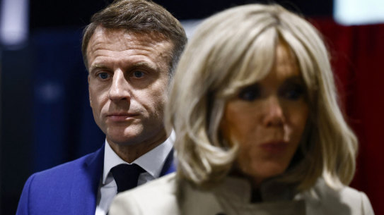 French President Emmanuel Macron and his wife Brigitte Macron stand in the voting station before voting in Le Touquet-Paris-Plage.