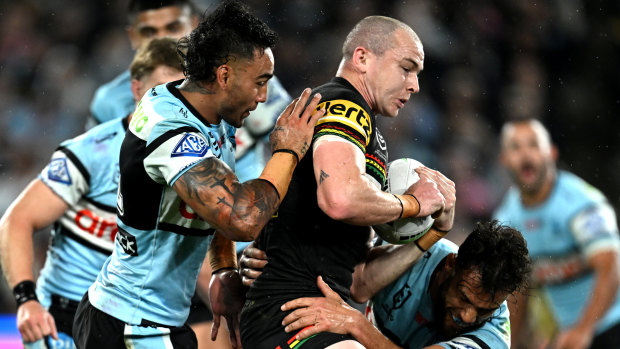 Dylan Edwards is swamped by the Cronulla kick-chase defence.