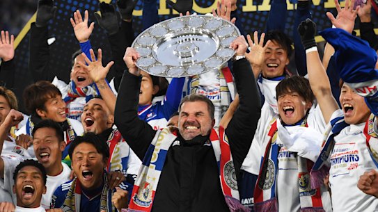 Ange Postecoglou raises the J.League trophy in triumph in Yokohama.