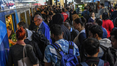 Commuters pour onto a train at Southern Cross Station on Thursday.