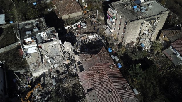 Rescuers search a damaged building after a magnitude 6.4 earthquake in Thumane, western Albania.