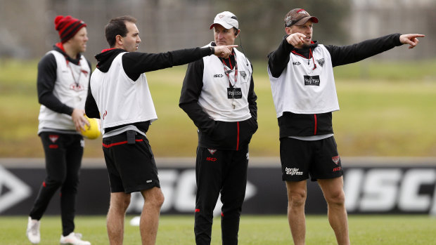 Essendon coach John Worsfold with his assistant coaches at training yesterday.