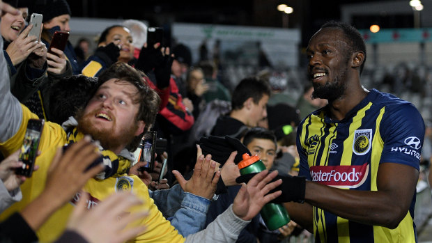 Fan favourite: Usain Bolt greets the fans following his Mariners debut.