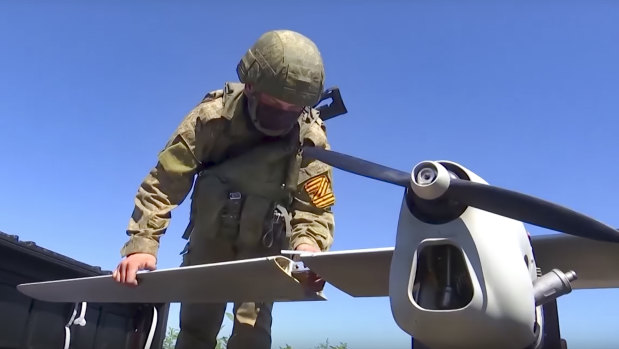 Rus ordusundan bu el ilanı fotoğrafında, bir asker fırlatmak için bir Orlan-10 keşif uçağı hazırlıyor.  Bir rapor, teknoloji devlerini Rusya'nın Ukrayna'ya karşı savaşına yardımcı olan BT bileşenlerini tedarik etmemeye çağırdı.