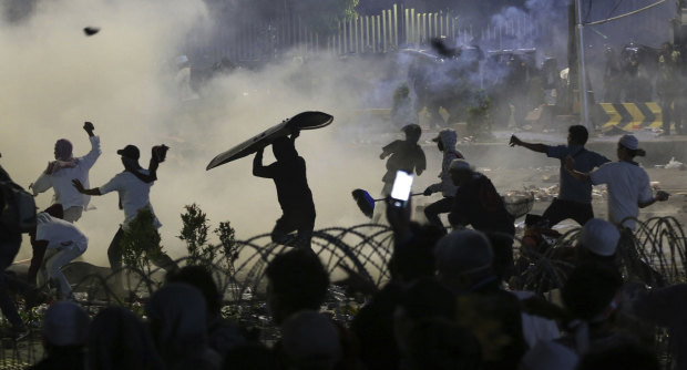 Hundreds of protesters have been taken into custody and accused of receiving cash rewards for rioting in Jakarta.