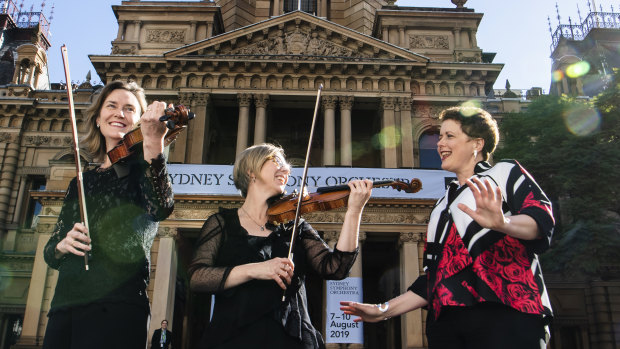 Musicians Rosemary Curtin (viola) and Sophie Cole (First violin)  with Emma Dunch, CEO of Sydney Symphony Orchestra outside Sydney Town Hall. 
