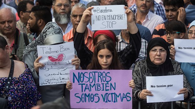 A girl holds a banner that reads: "We are also Victims" during a protest by the Muslim community condemning a jihadist terror attack in Barcelona, Spain, in 2017.