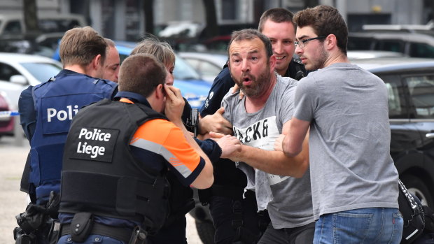 Police trying to calm a man at the scene of the shooting.