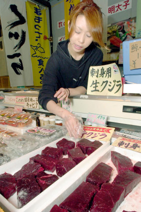Salesperson Yoko Yoshimura arranges cuts of raw whale meat at her shop at a port in Shimonoseki, Japan.