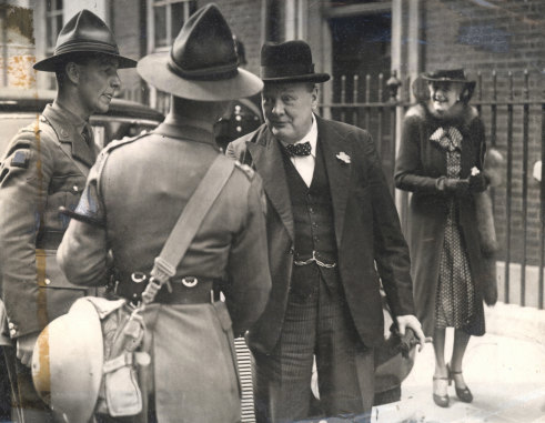 Winston Churchill, with wife Clementine in the background, chats to a group of New Zealanders in December 1940.