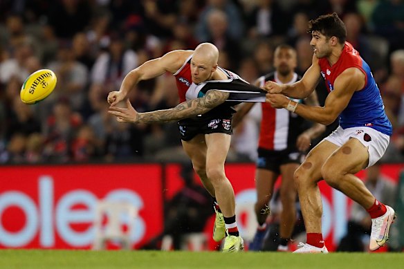 St Kilda’s Zak Jones is tackled by Melbourne’s Christian Petracca.