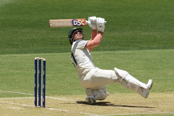 David Warner scoops a shot away for a boundary.