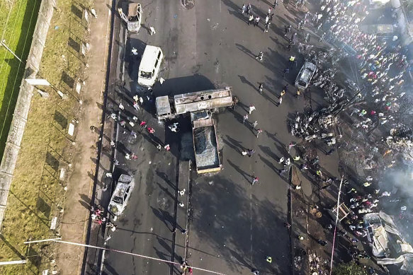 People gather around the charred oil tanker that exploded after being struck by a truck in the Wellington suburb of Sierra Leone’s capital Freetown.