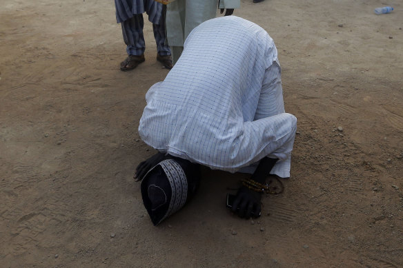 A father kisses the ground to give thanks for the safe return of his kidnapped son, Katsina, Nigeria. 