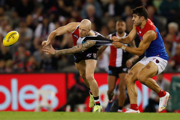 St Kilda’s Zak Jones is tackled by Melbourne’s Christian Petracca.