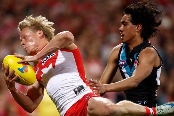 Isaac Heeney of the Swans and Port’s Jase Burgoyne in action.