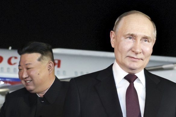 Russian President Vladimir Putin, right, walks as North Korea’s leader Kim Jong-un shakes hands with the Russian delegation.