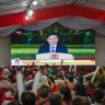 Attendees watch a broadcast of the swearing-in ceremony of Prime Minister Lawrence Wong in Singapore, on Wednesday evening.