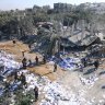 Palestinians clear building rubble following an Israeli airstrike in the Zuwayida district of central Gaza.