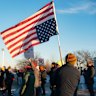 Demonstrators in St. Paul, Minnesota, carry an upside-down US flag in protest at a killing by an ICE agent.