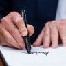 US President Donald Trump signs executive orders in the Oval Office of the White House in Washington, DC.