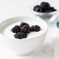 Greek yogurt with blackberries in white bowl on white background, closeup view Natural yoghurt with blackberries.
iStock image downloaded under the Good Food team account (contact syndication for reuse permissions).