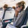 Woman sitting on a plane blowing her nose. Her protective face mask to reduce the spread of COVID-19 is under her chin. She is suffering from cold and flu symptoms. credit: istock
one time use for Traveller only