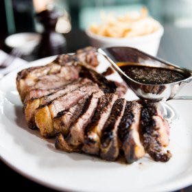 T-bone served with sauce au poivre.