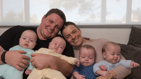 Sean Glachan, Taylah Tudehope-Glachan and their 6-month-old quadruplets Archie, Billy, Charlie and Daisy at home at Buff Point on the NSW Central Coast.