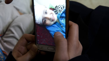 Aisha al-Lulu's mother Muna Awad shows a photo of the five-year-old in a Jerusalem hospital. 