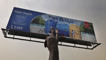 Sudanese protesters write graffiti on a billboard during a demonstration against the military council in Khartoum.