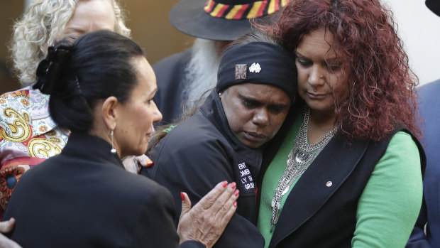 NSW MP Linda Burney, left, and federal Senator Malarndirri McCarthy comfort domestic violence victims' advocate Shirleen Campbell from the  Tangentyere Women's Family Safety Group in Alice Springs.