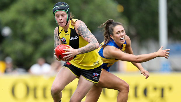 Burning bright: Tiger Tayla Stahla makes a quick getaway as West Coast's Hayley Bullas attempts a tackle during the practice match at Punt Road Oval in Richmond.