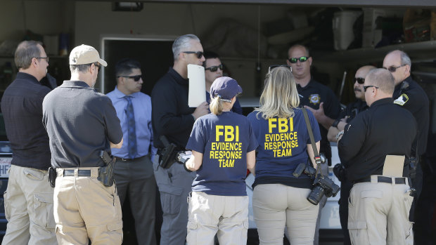 Authorities huddle outside a home searched in connection with the case in Citrus Heights, California.