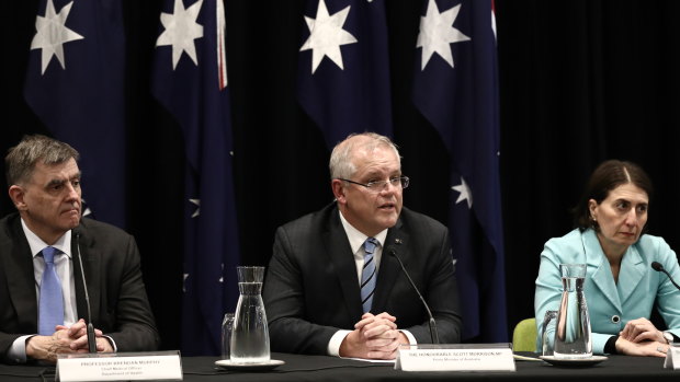 The footy opener plays on ... Prime Minister Scott Morrison, flanked by Chief Medical Officer Brendan Murphy and NSW Premier Gladys Berejiklian on Friday afternoon. 