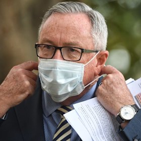 Health Minister Brad Hazzard dons a mask at Tuesday's coronavirus briefing. 