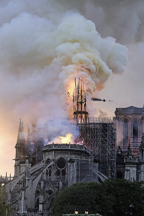 Flames and smoke rise as the spire on Notre Dame cathedral collapses in Paris.