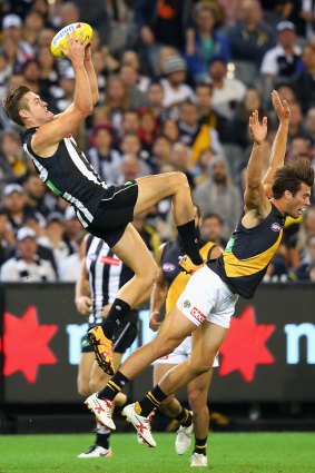 Darcy Moore of the Magpies marks over the top of Alex Rance.