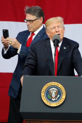 President Donald Trump delivers a speech to scouts as Secretary of Energy Rick Perry uses his phone at the 2017 National Boy Scout Jamboree.