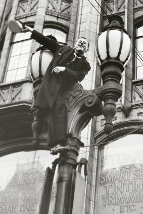 Man in Melbourne climbs on lamp post in celebration of the victory in Europe.