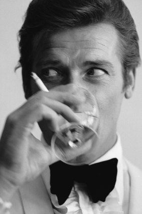 Roger Moore, well known for his roles as James Bond, downs a martini. 