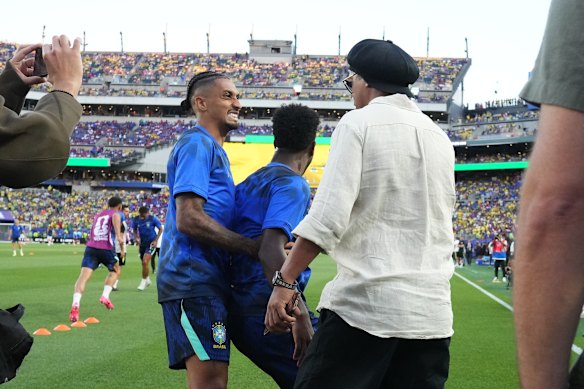 Former Brazilian soccer player Ronaldinho looks on Brazil’s Raphinha.
