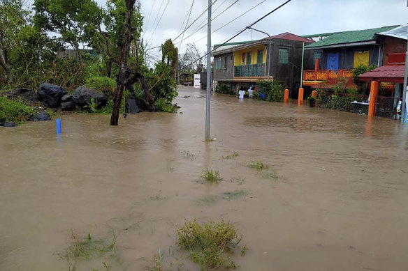 Residents walk along floodwaters in Daraga, Albay province, central Philippines as Typhoon Goni hit the area.