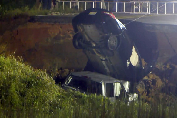 A vehicle is salvaged from a hole left on highway 26 near Lucedale, Mississippi on Tuesday.