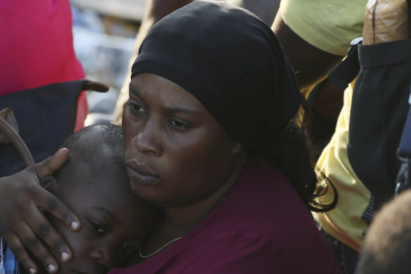 A woman on Abaco Island comforts her child.