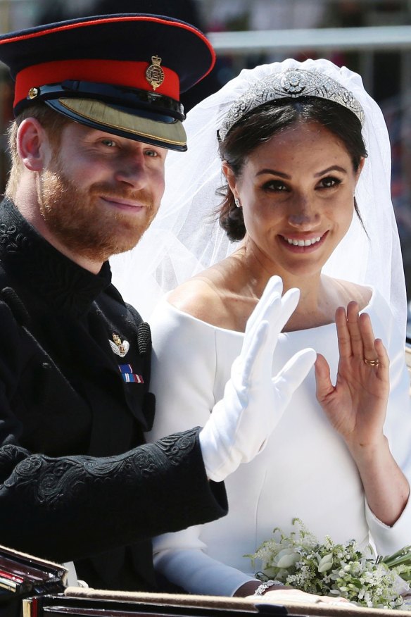 Prince Harry and Meghan Markle ride in an open-topped carriage through Windsor Castle.