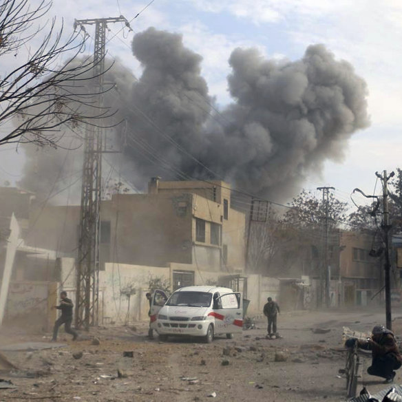 Civil defence workers arrive after air strikes hit a rebel-held suburb near Damascus.    