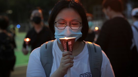 A women holds candle during a vigil to remember the victims of the 1989 Tiananmen Square Massacre.
