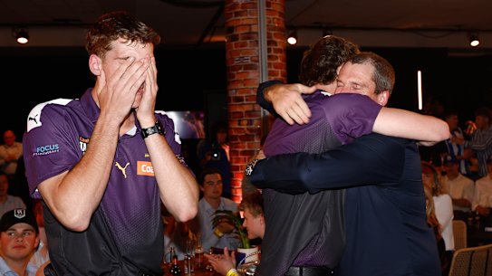 Matt Whitlock is embraced by his father after being drafted to North Melbourne, as his twin brother Jack Whitlock is overcome with emotion.